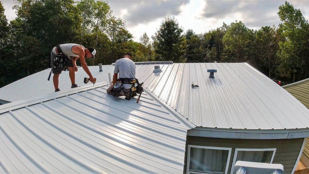 Roofers installing a metal roof panel on a residential home